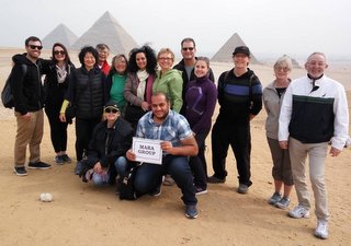 group of 14 people with three pyramids in the background