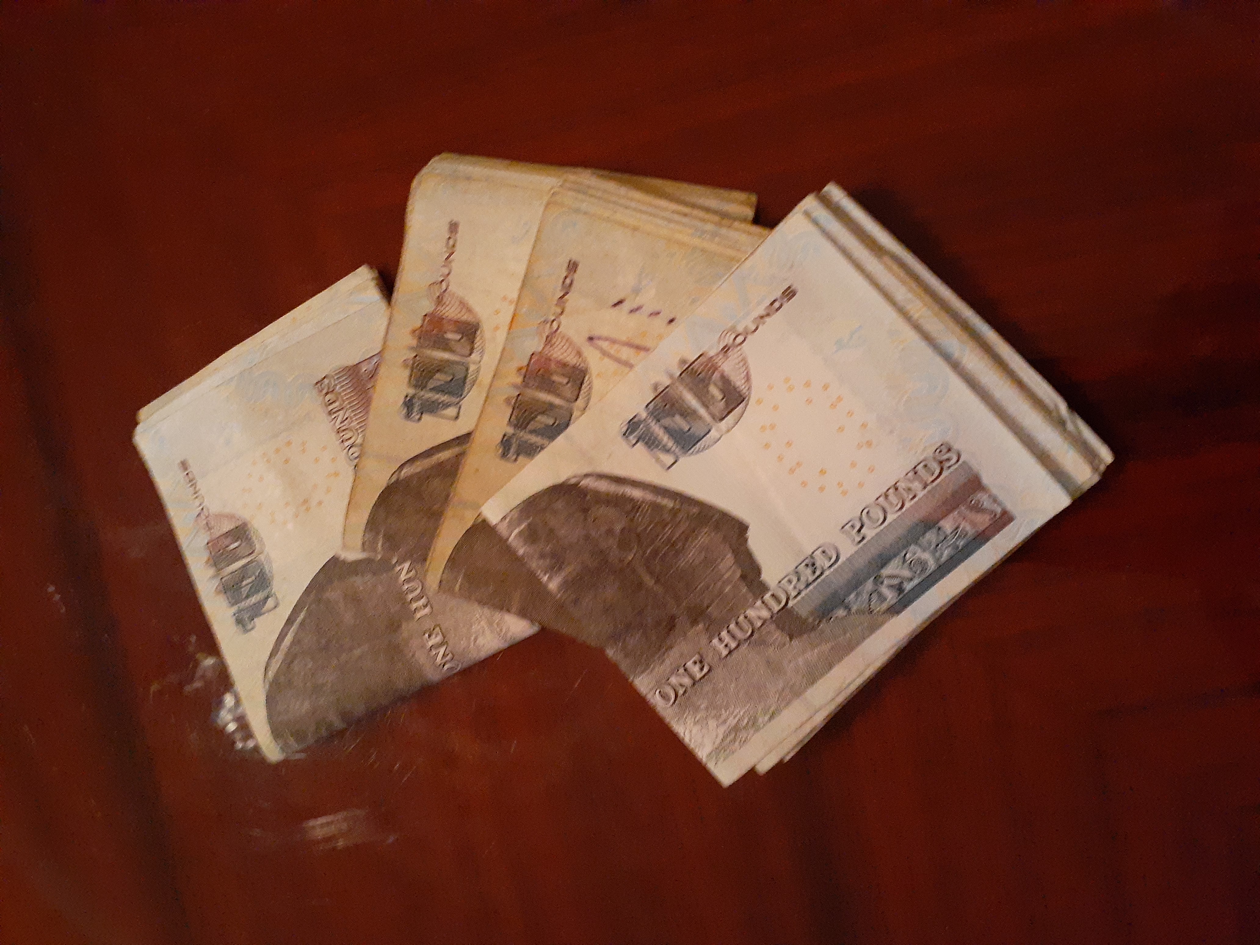 4 bundles of egypian 100 pound notes on a table