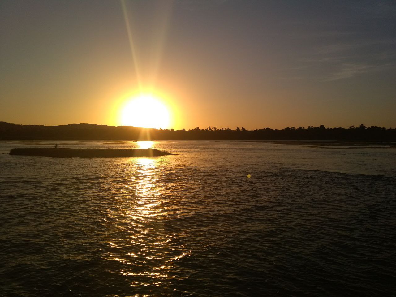 Sun half set over the Nile River at Luxor