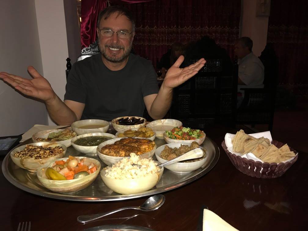 Guest at Mara House’s Salahadeen Restaurant admiring a silver tray with 12 large main-course dishes from the Salahadeen feast.