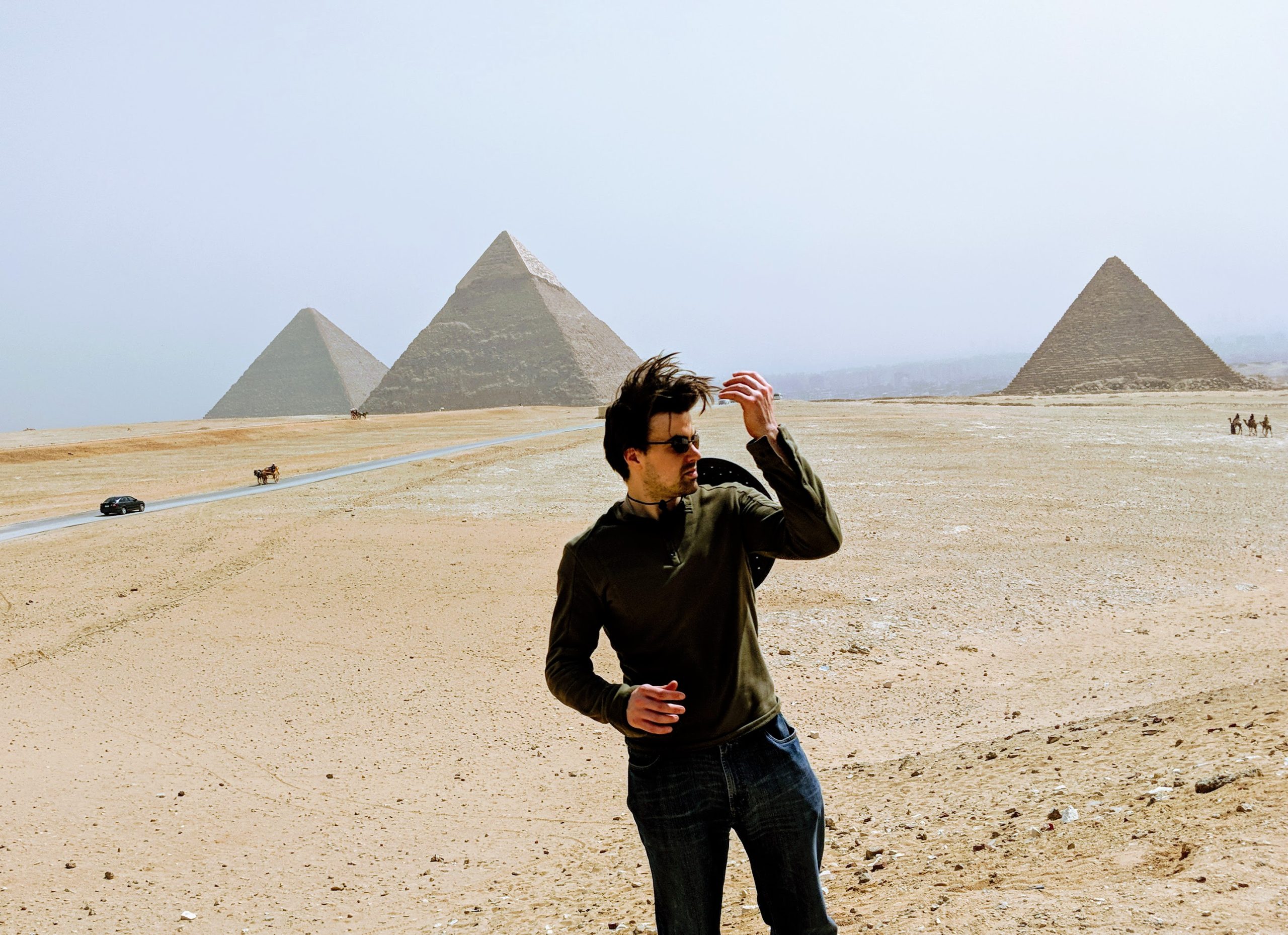 Young man in front of three pyramids at Giza