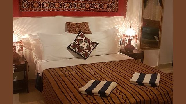 Our Double bedroom at Mara House double beed, bedside tables, wallhanging behind the bed